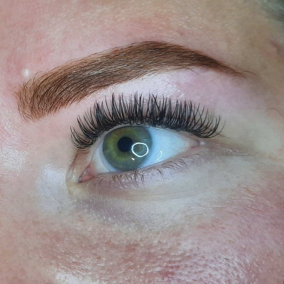 Gekleurde wenkbrauw en volle wimpers bij een groen oog