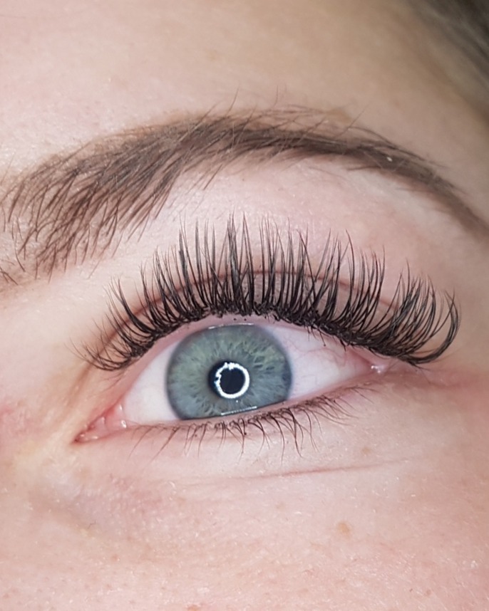 Lange, gekrulde wimperextensions bij een blauw oog